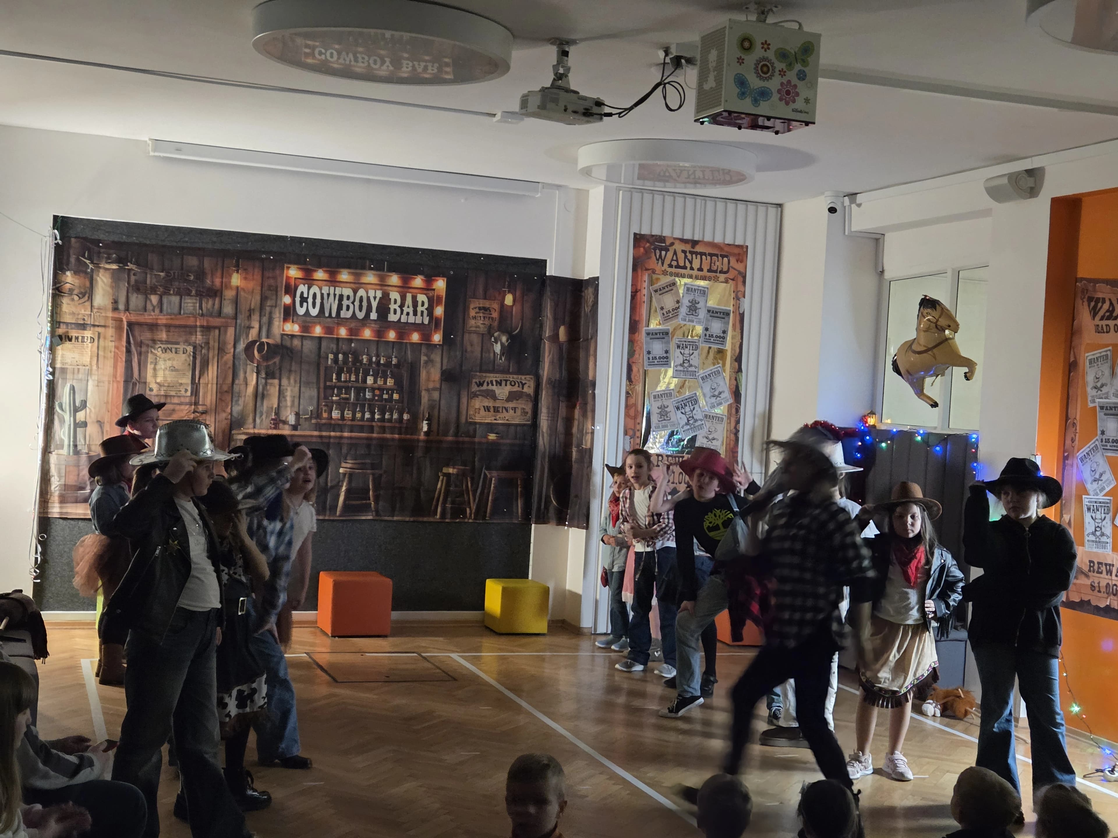 Uczniowie występują na scenie przed publicznością.